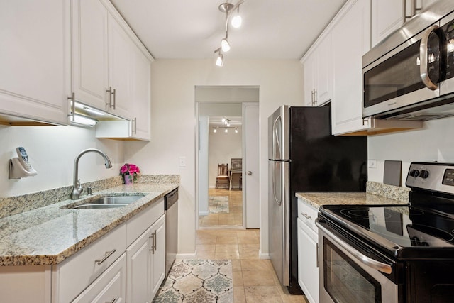 1901 Emerson Ave S Unit 104, Minneapolis, MN 55403 - kitchen featuring appliances with stainless steel finishes, white cabinets, light stone counters, light tile patterned floors, and ceiling fan