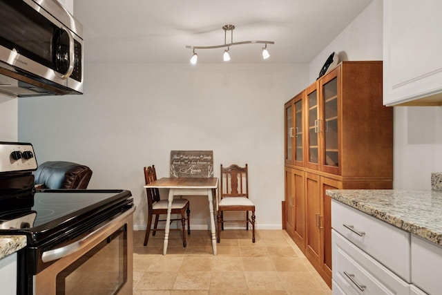 1901 Emerson Ave S Unit 104, Minneapolis, MN 55403 - kitchen with stainless steel appliances, a barn door, light stone counters, and glass insert cabinets