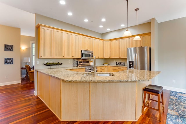 448 3rd St, Excelsior, MN 55331 - kitchen featuring appliances with stainless steel finishes, light brown cabinetry, a peninsula, light stone countertops, and recessed lighting