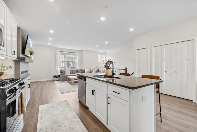 1517 Timberwood Ln, West Saint Paul, MN 55118 - kitchen featuring range with gas stovetop, stainless steel dishwasher, a kitchen bar, light wood-style flooring, and recessed lighting