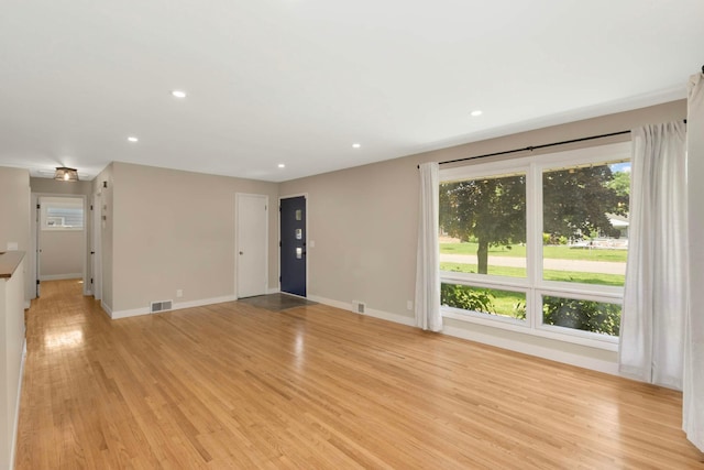7609 65th Ave N, Brooklyn Park, MN 55428 - unfurnished living room featuring plenty of natural light, light wood-type flooring, recessed lighting, and baseboards