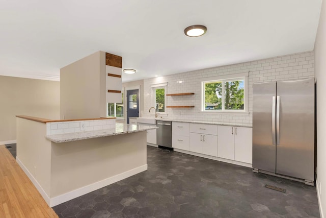 7609 65th Ave N, Brooklyn Park, MN 55428 - kitchen featuring appliances with stainless steel finishes, white cabinets, light stone counters, backsplash, and baseboards