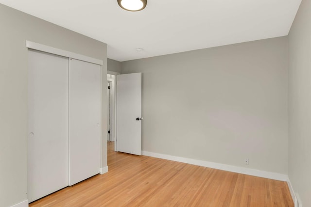 7609 65th Ave N, Brooklyn Park, MN 55428 - unfurnished bedroom with baseboards, light wood finished floors, and a closet