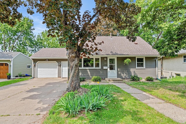 4618 Jefferson St NE, Columbia Heights, MN 55421 - view of front facade featuring asphalt driveway, a garage, roof with shingles, and a front yard