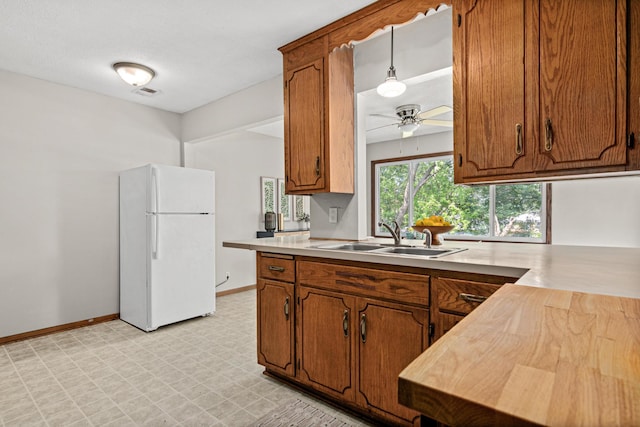4618 Jefferson St NE, Columbia Heights, MN 55421 - kitchen featuring freestanding refrigerator, a sink, brown cabinets, and light flooring