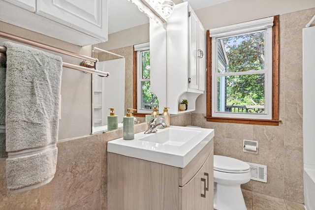 4618 Jefferson St NE, Columbia Heights, MN 55421 - bathroom with vanity, toilet, tile walls, and tile patterned floors