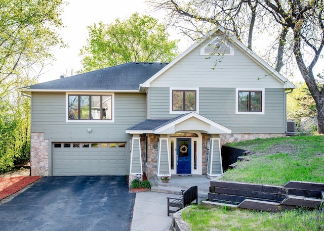 1070 Jefferson Ave, Saint Paul, MN 55105 - view of front facade featuring an attached garage, driveway, stone siding, and a shingled roof