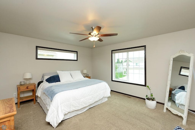 5962 57th Ave S, Fargo, ND 58104 - bedroom featuring multiple windows, light colored carpet, baseboards, and a ceiling fan