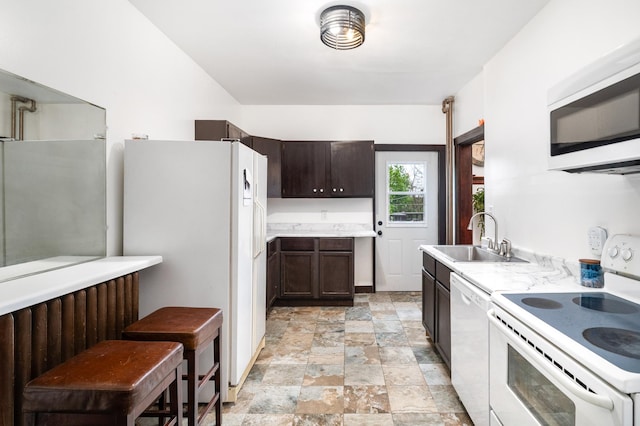 416 6th St, Duluth, MN 55805 - kitchen featuring white appliances, a sink, dark brown cabinets, light stone finish floors, and light countertops