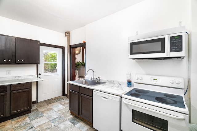 416 6th St, Duluth, MN 55805 - kitchen featuring white appliances, a sink, dark brown cabinetry, light countertops, and stone finish floors