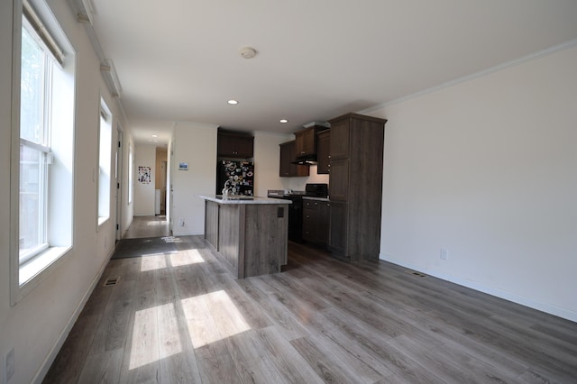 16962 Kenrick Ave Unit 7, Lakeville, MN 55044 - kitchen featuring an island with sink, black stove, light wood-style flooring, crown molding, and baseboards