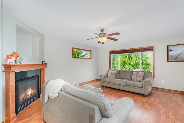 29259 Wildwood Rd, Chisago City, MN 55013 - living area with a glass covered fireplace, ceiling fan, and light wood finished floors