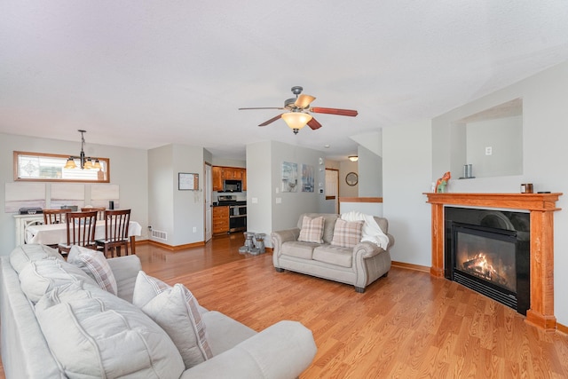 29259 Wildwood Rd, Chisago City, MN 55013 - living area featuring light wood-style flooring, a ceiling fan, and a glass covered fireplace