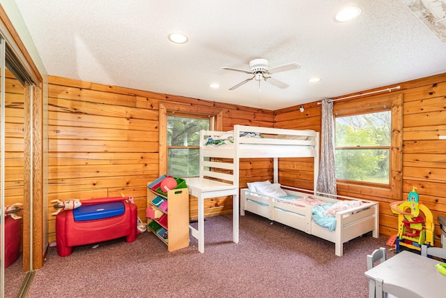W7340 163rd Ave, Hager City, WI 54014 - bedroom featuring multiple windows, carpet flooring, wooden walls, recessed lighting, and a textured ceiling