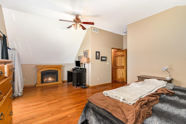 W7340 163rd Ave, Hager City, WI 54014 - bedroom featuring lofted ceiling, light wood-style flooring, a glass covered fireplace, and a ceiling fan