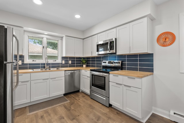 8401 Meadow Lake Rd N, New Hope, MN 55428 - kitchen with appliances with stainless steel finishes, wood counters, a sink, a baseboard heating unit, and recessed lighting