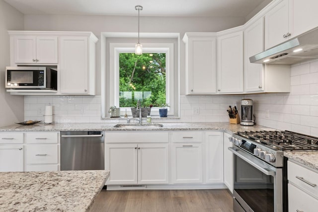 7465 Glengarry Pl, Eden Prairie, MN 55344 - kitchen featuring stainless steel appliances, under cabinet range hood, white cabinets, and light wood-style flooring
