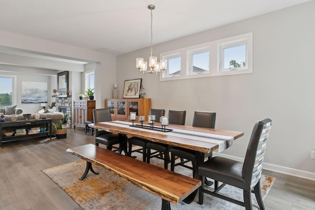 7465 Glengarry Pl, Eden Prairie, MN 55344 - dining space featuring a chandelier, light wood-type flooring, and a fireplace