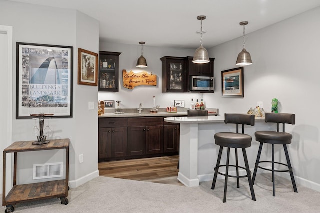 7465 Glengarry Pl, Eden Prairie, MN 55344 - indoor wet bar with stainless steel microwave, light carpet, and hanging light fixtures
