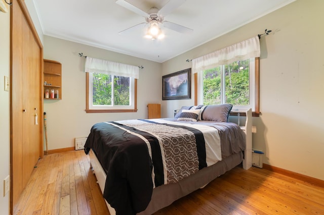 1928 Loop Rd, Two Harbors, MN 55616 - bedroom featuring light wood finished floors, multiple windows, baseboards, ceiling fan, and crown molding