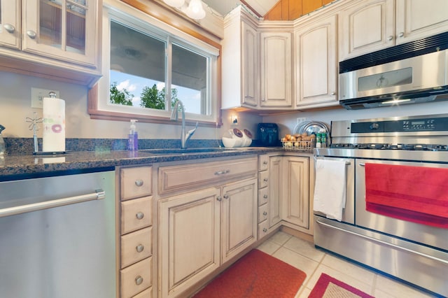 1928 Loop Rd, Two Harbors, MN 55616 - kitchen with appliances with stainless steel finishes, cream cabinets, light tile patterned floors, and a sink