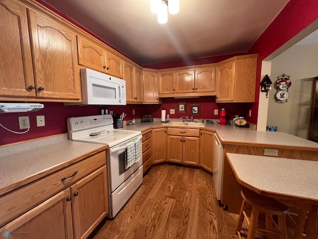 2711 12th St S Unit A2, Fargo, ND 58103 - kitchen with white appliances, wood finished floors, light countertops, and a peninsula