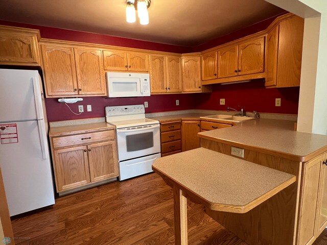 2711 12th St S Unit A2, Fargo, ND 58103 - kitchen featuring white appliances, a peninsula, dark wood-style flooring, and light countertops