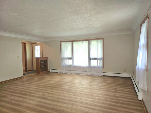 735 Main St N, Hutchinson, MN 55350 - unfurnished room with wood finished floors, a textured ceiling, and baseboard heating