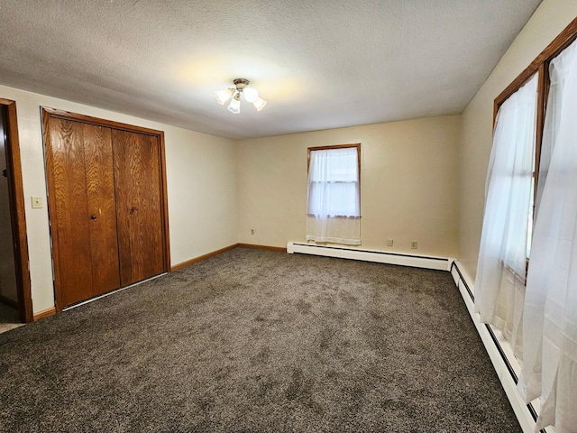 735 Main St N, Hutchinson, MN 55350 - unfurnished bedroom with a baseboard heating unit, dark carpet, and a textured ceiling