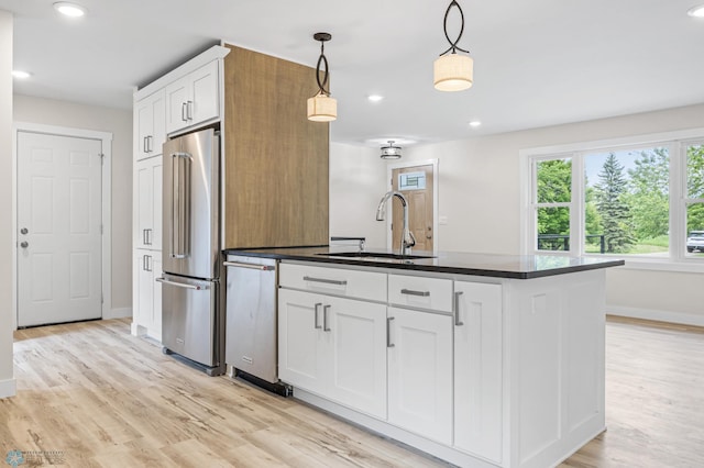 11763 230th St N, Keene Twp, MN 56549 - kitchen featuring stainless steel appliances, a sink, dark countertops, baseboards, and light wood-type flooring