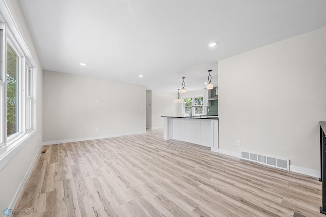 11763 230th St N, Keene Twp, MN 56549 - unfurnished living room with light wood-type flooring, a sink, baseboards, and recessed lighting