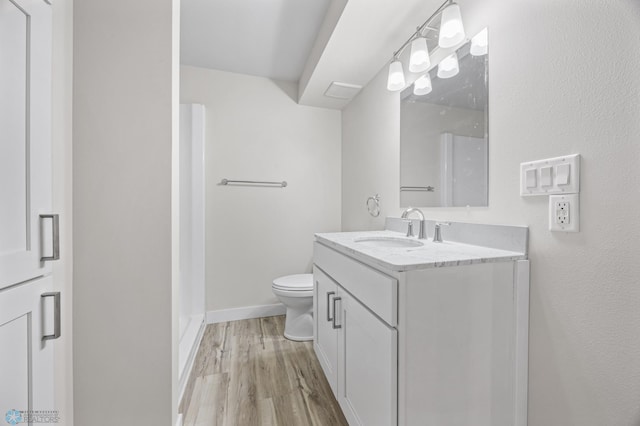 11763 230th St N, Keene Twp, MN 56549 - bathroom with toilet, wood finished floors, vanity, and baseboards