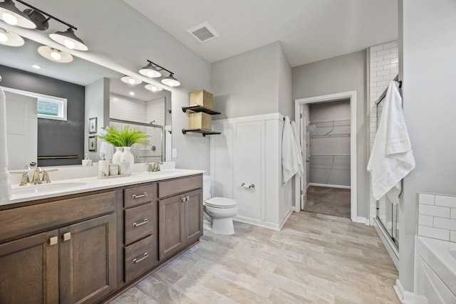 14645 Cloquet St, Dayton, MN 55327 - full bathroom featuring a stall shower, double vanity, a spacious closet, a decorative wall, and a wainscoted wall
