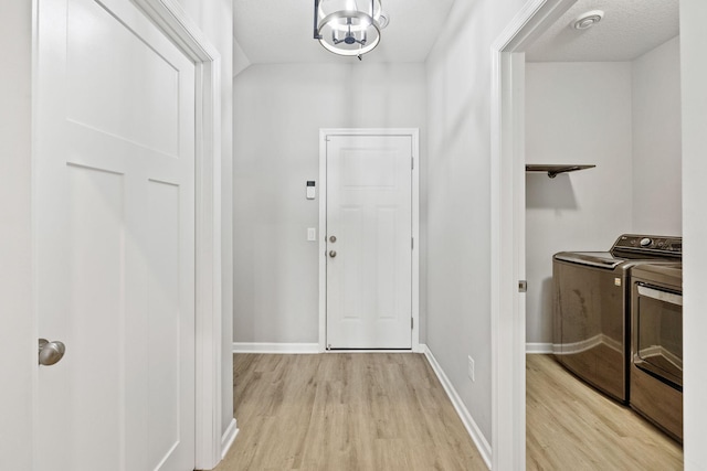 14645 Cloquet St, Dayton, MN 55327 - foyer entrance featuring independent washer and dryer, light wood finished floors, and a chandelier