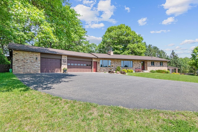 17000 Jackal St NW, Ramsey, MN 55303 - ranch-style house featuring an attached garage, asphalt driveway, a front yard, brick siding, and a chimney