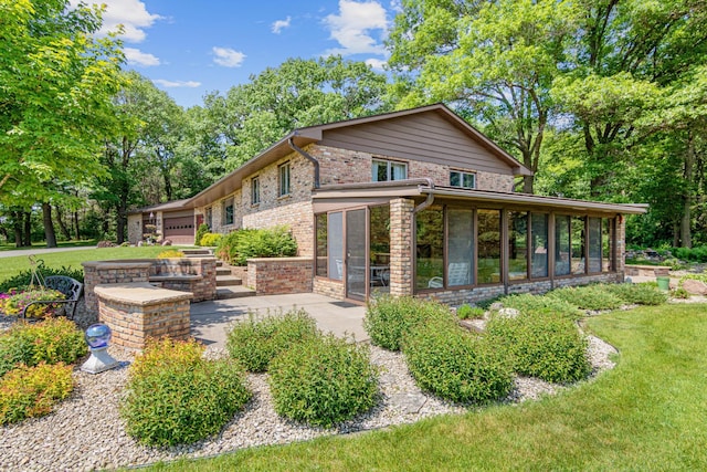 17000 Jackal St NW, Ramsey, MN 55303 - back of property with a sunroom, brick siding, and a yard