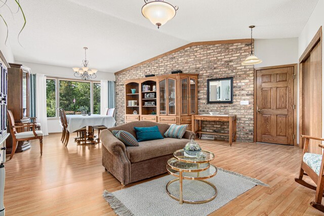 17000 Jackal St NW, Ramsey, MN 55303 - living area with vaulted ceiling, light wood finished floors, brick wall, and a chandelier