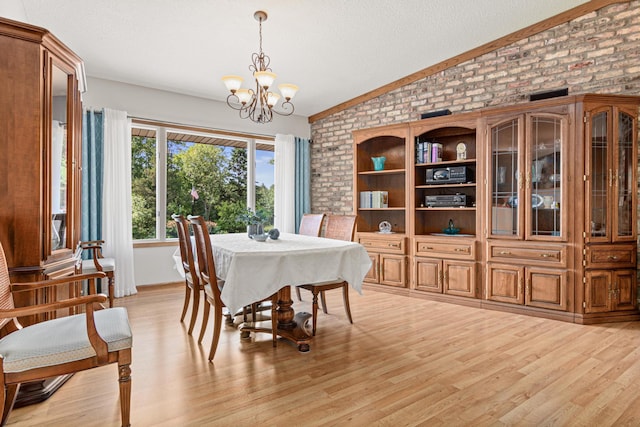17000 Jackal St NW, Ramsey, MN 55303 - dining room featuring brick wall, vaulted ceiling, a chandelier, light wood finished floors, and a textured ceiling