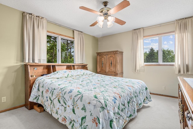 17000 Jackal St NW, Ramsey, MN 55303 - bedroom featuring light carpet, multiple windows, ceiling fan, and a textured ceiling