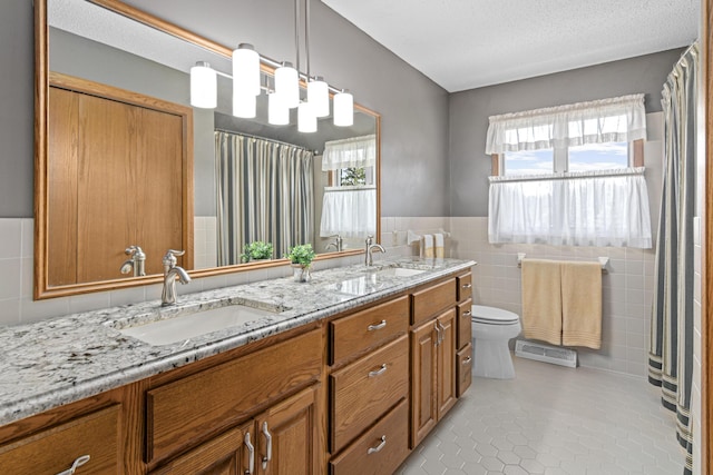 17000 Jackal St NW, Ramsey, MN 55303 - bathroom with tile walls, double vanity, tile patterned flooring, a wainscoted wall, and a shower with shower curtain