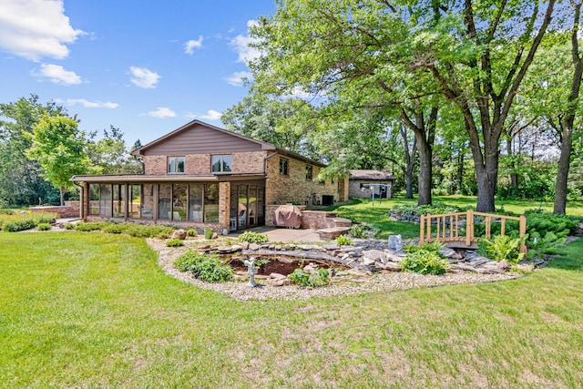 17000 Jackal St NW, Ramsey, MN 55303 - back of property with a patio, brick siding, and a lawn