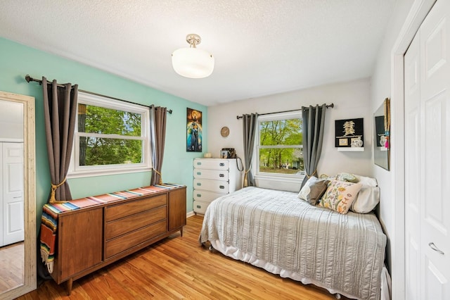 2500 Ensign Ave N, Golden Valley, MN 55427 - bedroom featuring multiple windows, light wood-style flooring, and a textured ceiling