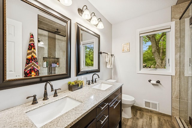 2500 Ensign Ave N, Golden Valley, MN 55427 - bathroom featuring a shower stall, wood finished floors, double vanity, and plenty of natural light