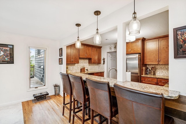 2500 Ensign Ave N, Golden Valley, MN 55427 - kitchen with freestanding refrigerator, backsplash, light wood-style floors, and pendant lighting