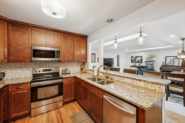 2500 Ensign Ave N, Golden Valley, MN 55427 - kitchen with stainless steel appliances, light wood finished floors, a peninsula, decorative backsplash, and recessed lighting