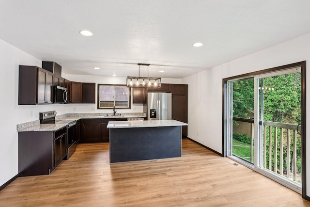 933 Beech St, Saint Paul, MN 55106 - kitchen featuring stainless steel appliances, dark brown cabinetry, a center island, light wood-style flooring, and recessed lighting