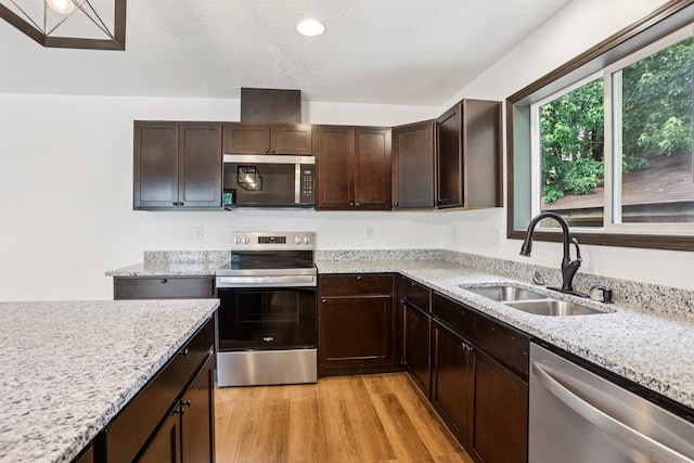 933 Beech St, Saint Paul, MN 55106 - kitchen with appliances with stainless steel finishes, dark brown cabinets, light stone counters, light wood-type flooring, and recessed lighting