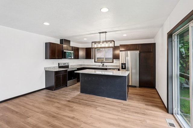 933 Beech St, Saint Paul, MN 55106 - kitchen featuring appliances with stainless steel finishes, dark brown cabinetry, plenty of natural light, a center island, and recessed lighting