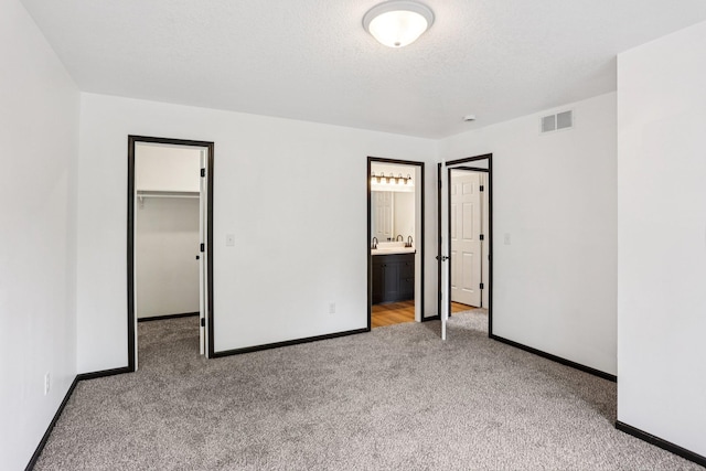 933 Beech St, Saint Paul, MN 55106 - unfurnished bedroom with carpet flooring, a spacious closet, a closet, ensuite bath, and a textured ceiling