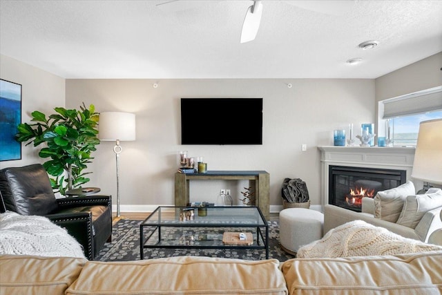 1702 Lakeshore Dr Unit 3, Lake City, MN 55041 - living room featuring a glass covered fireplace, a textured ceiling, and ceiling fan